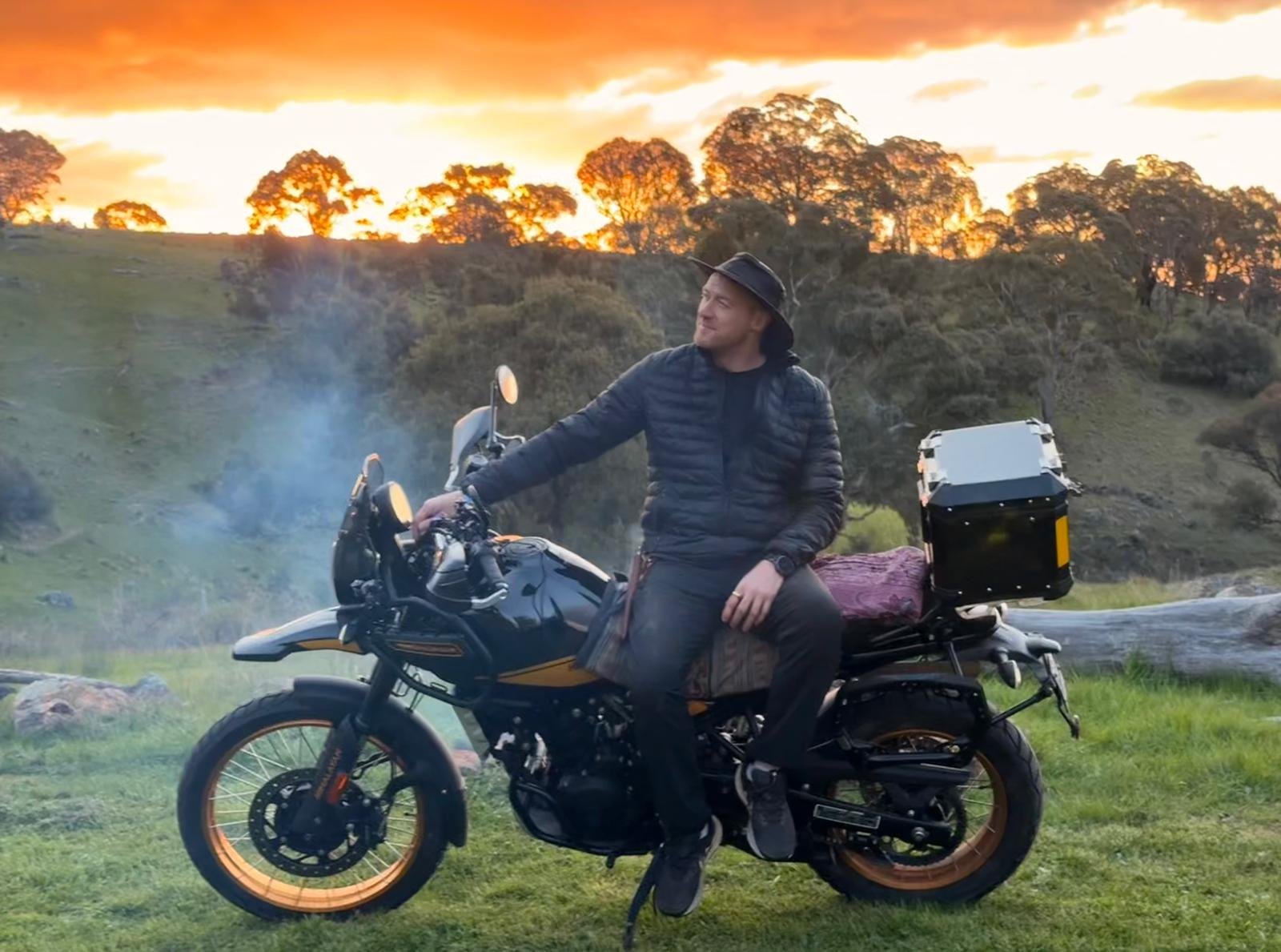 Wide · Hunter loaded by the river, fire smoke across the grass